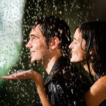 Young happy amorous couple hugging under a rain